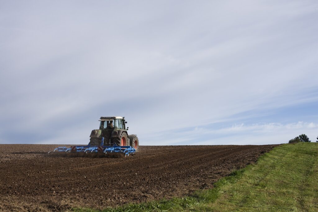 Bilden visar en traktor som kultiverar jorden med en veterantraktor som kan vara förtjänt av olika traktortillbehör som harv, betesklippare och toppstag alternativ toppstång bland reservdelarna till veterantraktorn